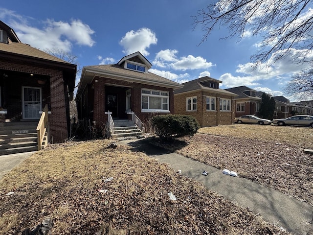 view of front of home featuring covered porch and brick siding