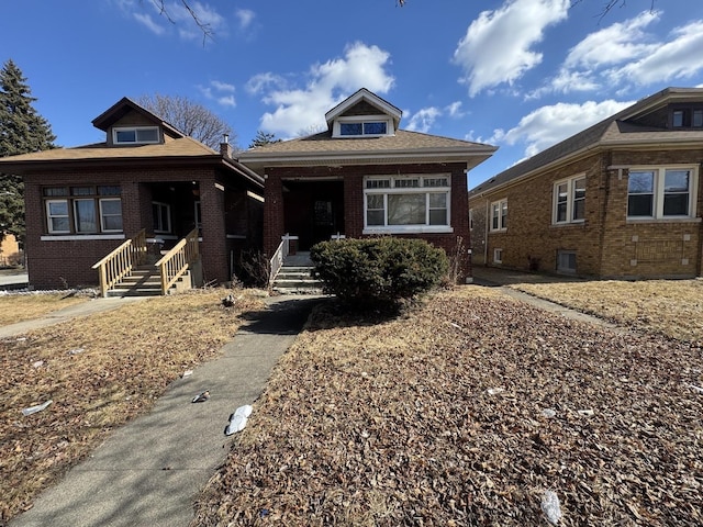 bungalow featuring covered porch and brick siding