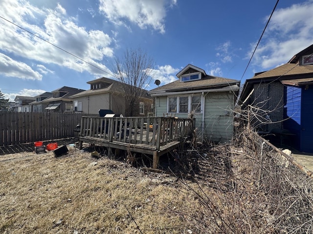 back of property featuring a deck and fence