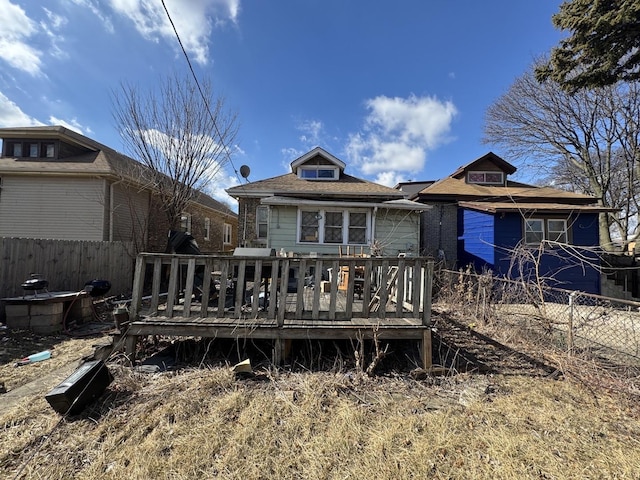 rear view of house featuring fence and a wooden deck