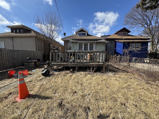 rear view of property featuring a fenced backyard and a deck