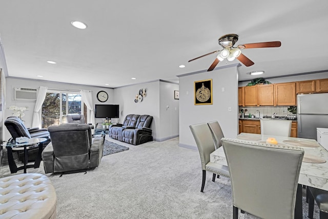 living room with recessed lighting, light colored carpet, a ceiling fan, baseboards, and crown molding