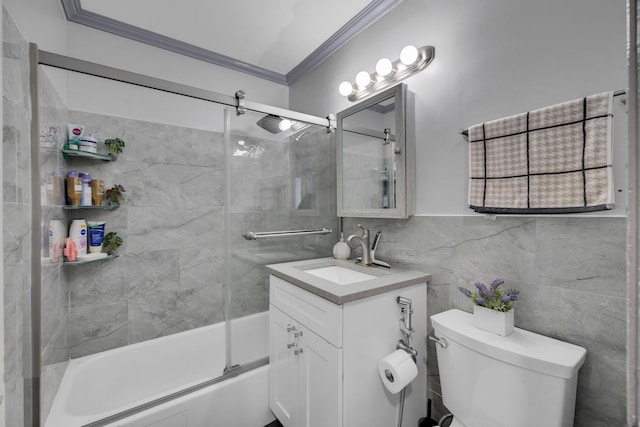 full bath featuring toilet, shower / bath combination with glass door, crown molding, vanity, and tile walls