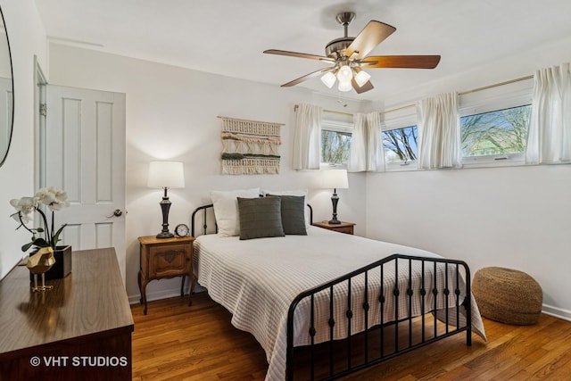 bedroom featuring a ceiling fan, baseboards, and wood finished floors