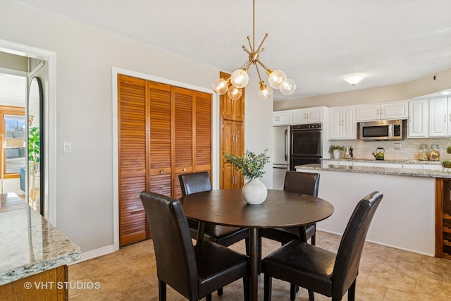 dining space featuring a notable chandelier and baseboards