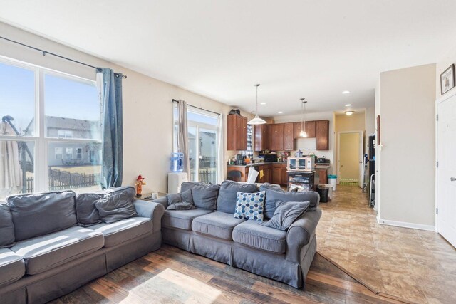 living area with recessed lighting, light wood-type flooring, and baseboards