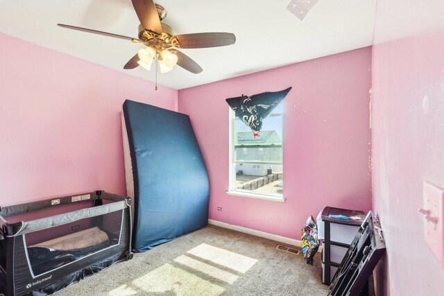 carpeted bedroom with baseboards, visible vents, and ceiling fan