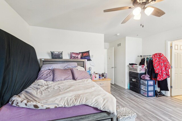 bedroom with visible vents, baseboards, light wood-style floors, and ceiling fan