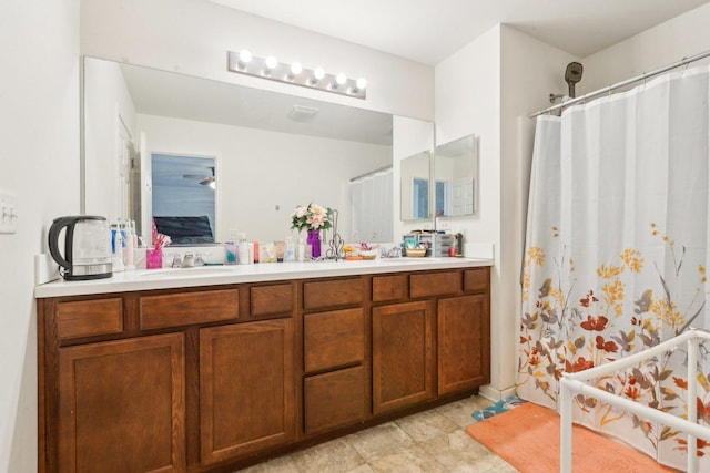 ensuite bathroom with a shower with shower curtain, double vanity, and a sink