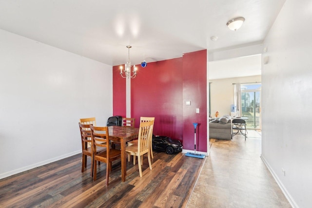 dining area featuring baseboards, an inviting chandelier, and wood finished floors