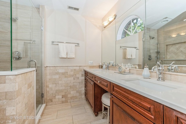 full bathroom featuring a sink, tile walls, and a shower stall