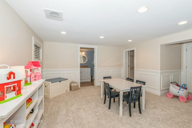 recreation room featuring light carpet, a wainscoted wall, visible vents, and recessed lighting