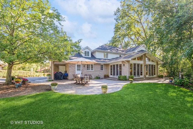 rear view of property featuring entry steps, a patio, a yard, and brick siding