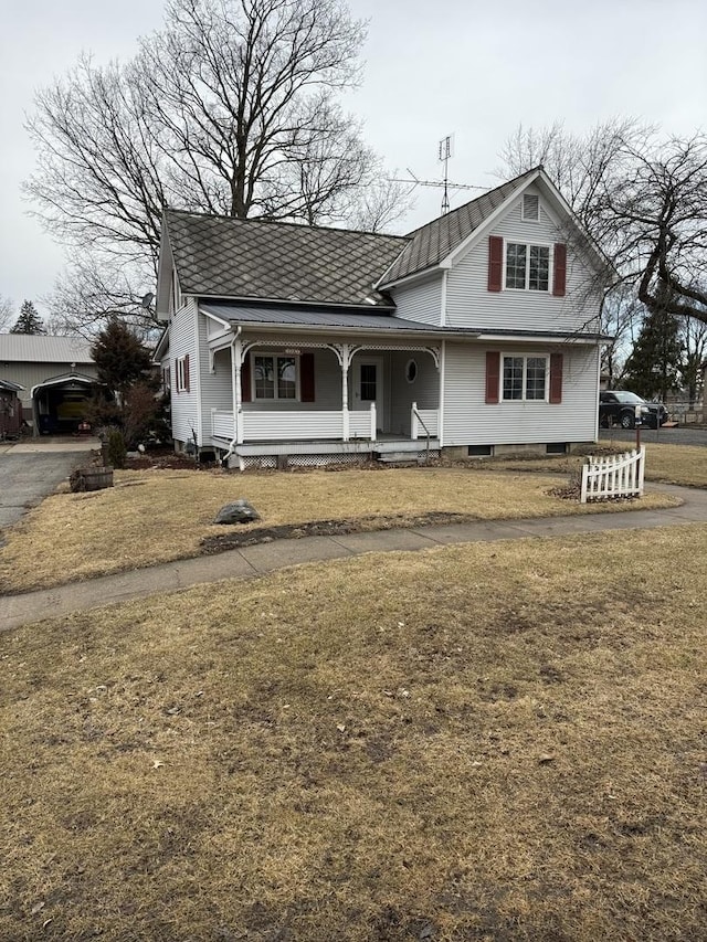 view of front facade featuring driveway, a porch, and a front yard