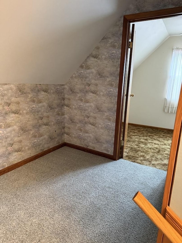 additional living space featuring lofted ceiling, carpet, and baseboards