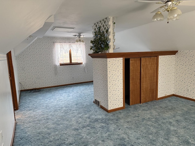 additional living space featuring wallpapered walls, visible vents, lofted ceiling, ceiling fan, and carpet