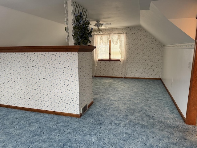 additional living space with a ceiling fan, visible vents, vaulted ceiling, baseboards, and carpet