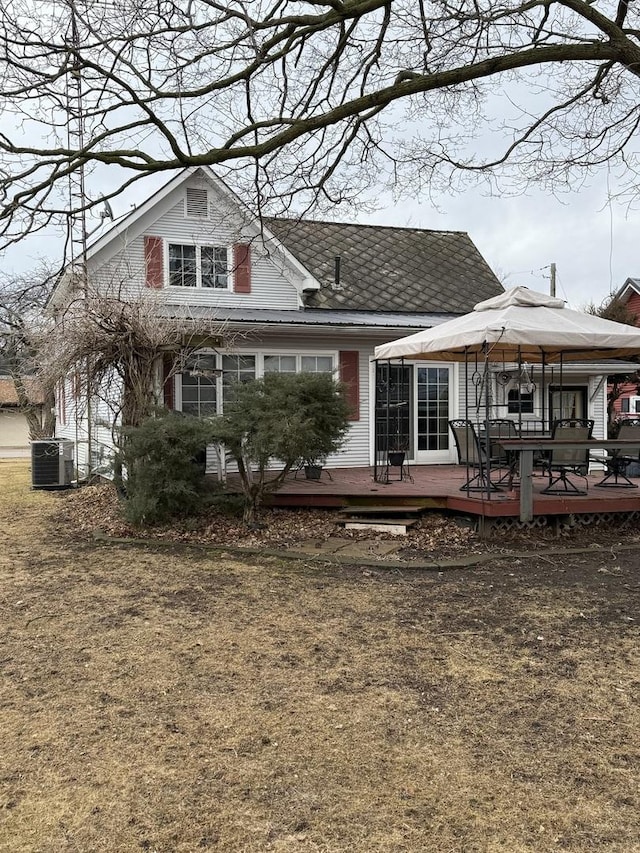 rear view of house featuring a lawn, a deck, and central AC