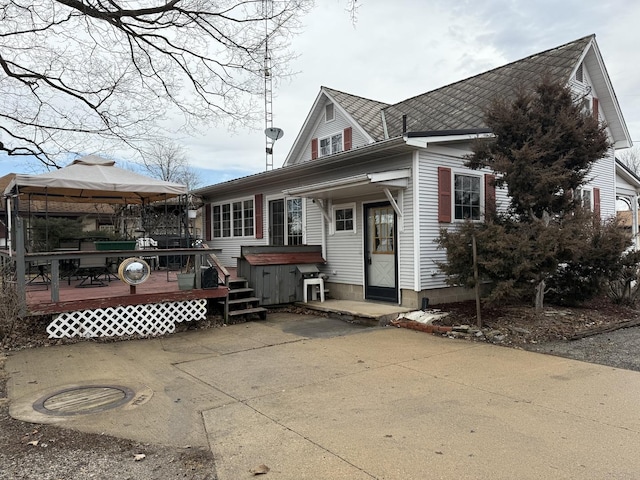 view of front of house with a gazebo, a wooden deck, and a hot tub