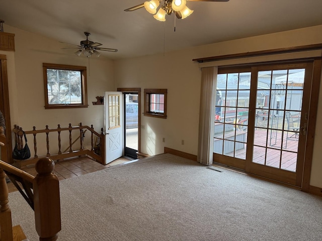 unfurnished room featuring light tile patterned floors, visible vents, light carpet, ceiling fan, and baseboards