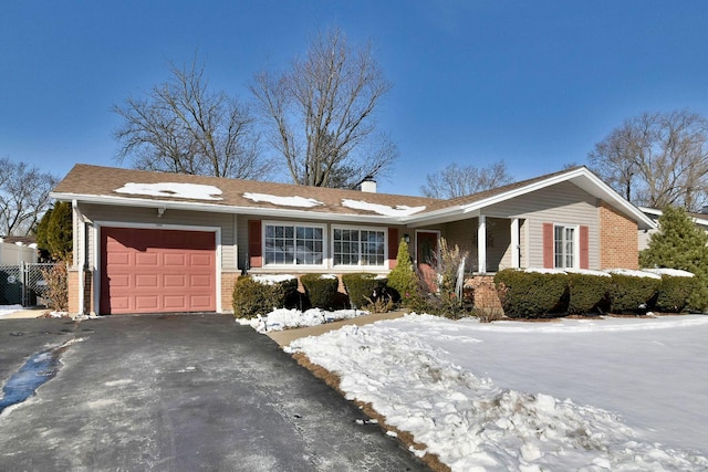 ranch-style home with aphalt driveway, brick siding, a chimney, and an attached garage