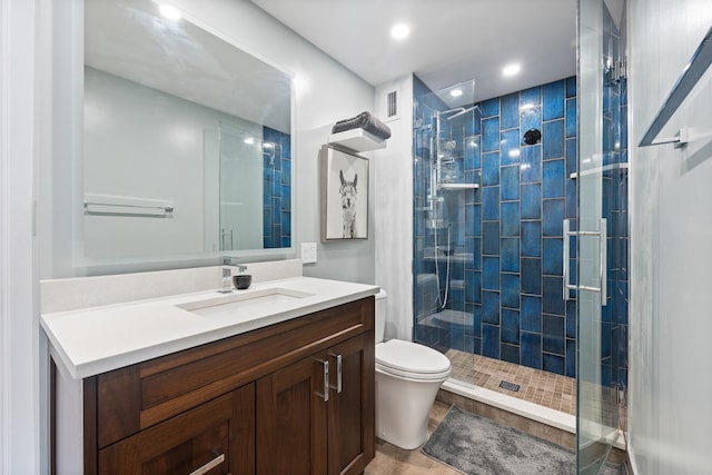 full bath with visible vents, vanity, a shower stall, and toilet