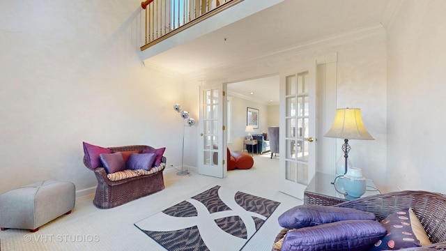 sitting room with carpet floors, french doors, and crown molding