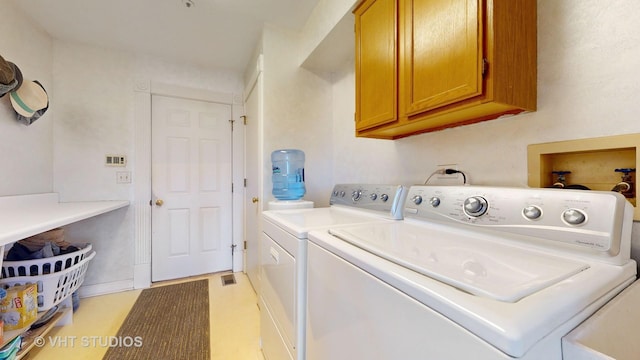 washroom with cabinet space and washer and clothes dryer