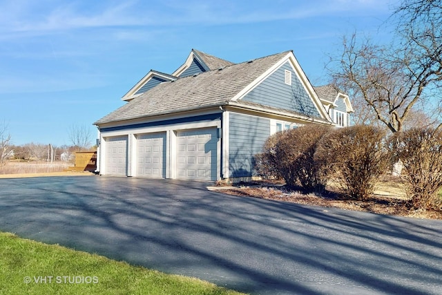 view of property exterior featuring a garage and driveway