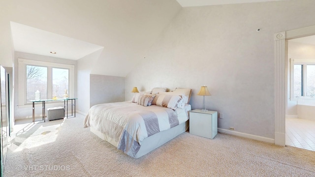 carpeted bedroom with vaulted ceiling and baseboards