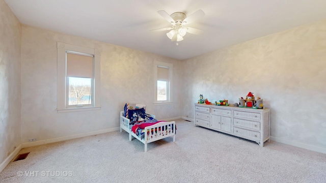 bedroom featuring light carpet, a ceiling fan, visible vents, and baseboards