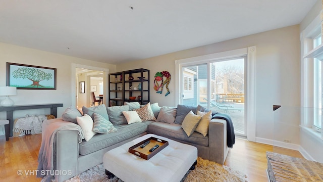 living area with light wood-style flooring and baseboards