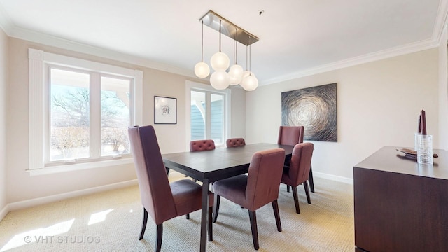 dining space featuring light carpet, an inviting chandelier, baseboards, and ornamental molding