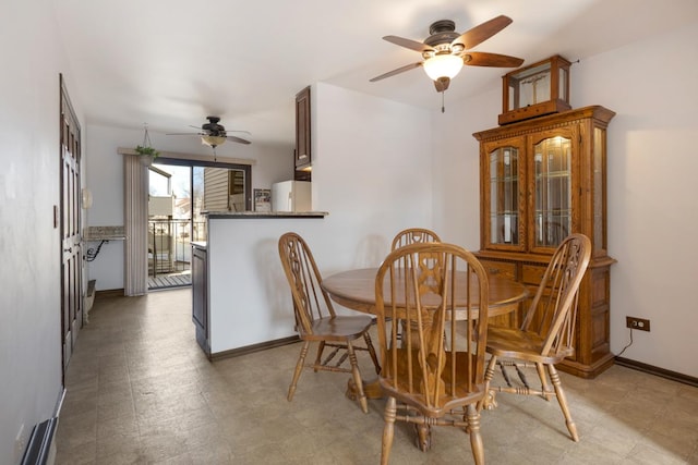 dining space with light floors, ceiling fan, and baseboards