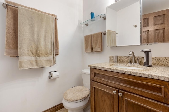 half bathroom with vanity and toilet