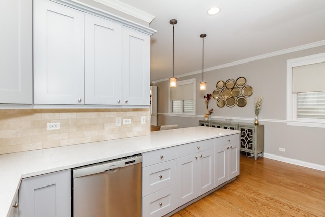 kitchen with dishwasher, decorative light fixtures, light countertops, crown molding, and backsplash