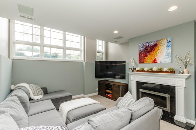 living room with recessed lighting, visible vents, a high end fireplace, light carpet, and baseboards