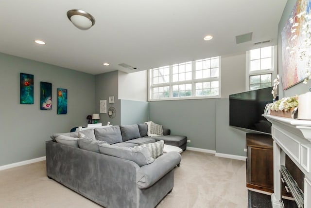 living room featuring visible vents, baseboards, light colored carpet, a fireplace, and recessed lighting