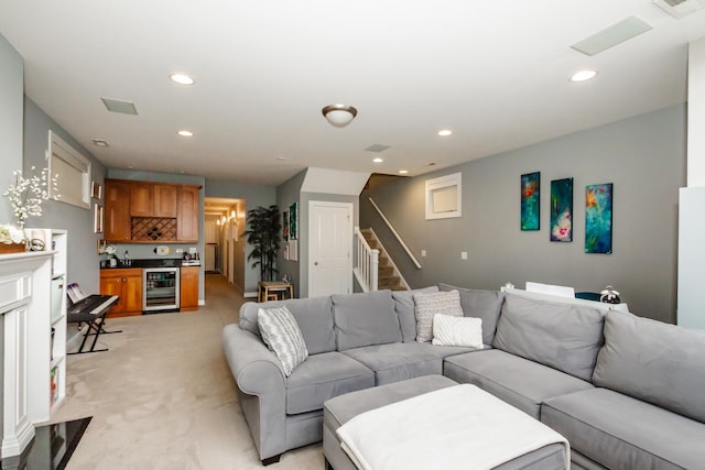 living room with light carpet, beverage cooler, stairs, and recessed lighting