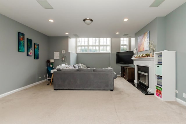 living area with light carpet, baseboards, a fireplace with flush hearth, and recessed lighting