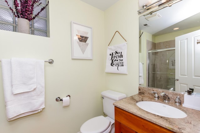 full bath with visible vents, a stall shower, vanity, and toilet