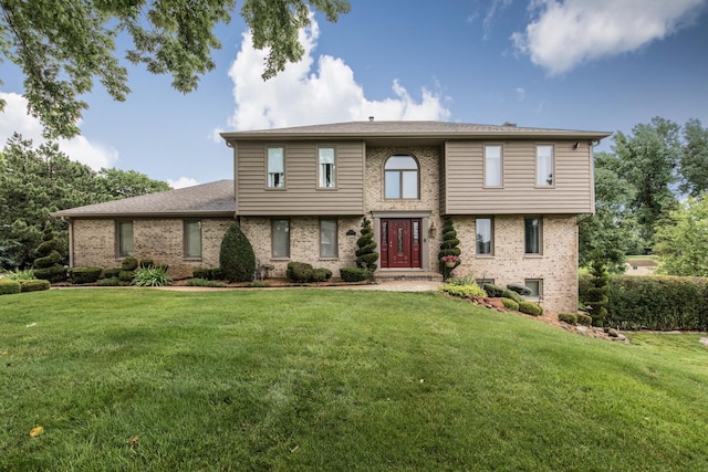 view of front of home with a front lawn and brick siding