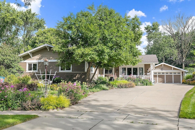 view of front facade with a detached garage and covered porch