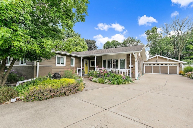 single story home with brick siding, a porch, a detached garage, and an outdoor structure