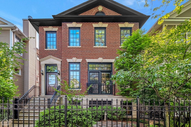 view of front facade with a fenced front yard and brick siding