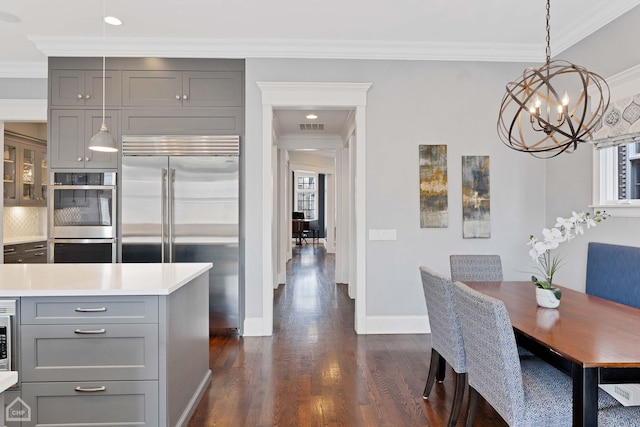 dining space with baseboards, visible vents, dark wood-style flooring, and ornamental molding