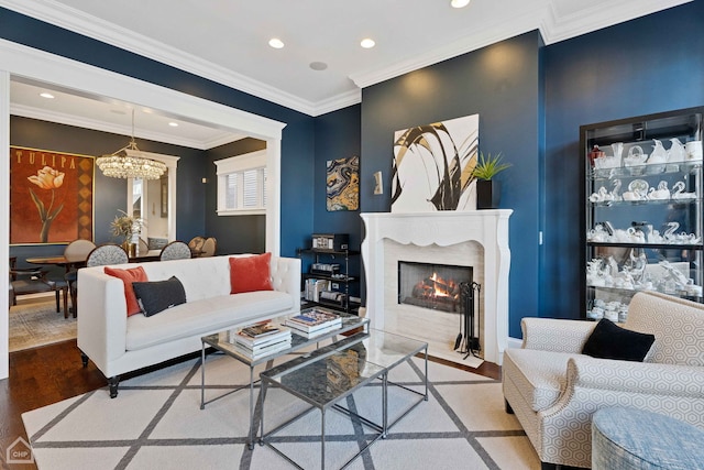 living room featuring a chandelier, recessed lighting, ornamental molding, and wood finished floors