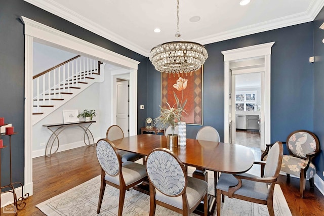 dining room featuring a chandelier, crown molding, baseboards, and wood finished floors