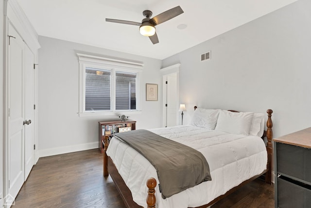 bedroom featuring dark wood-style floors, baseboards, visible vents, and ceiling fan