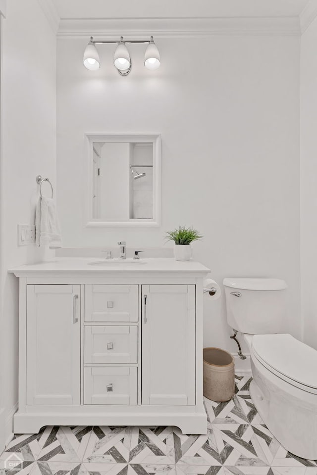 bathroom featuring vanity, toilet, and crown molding